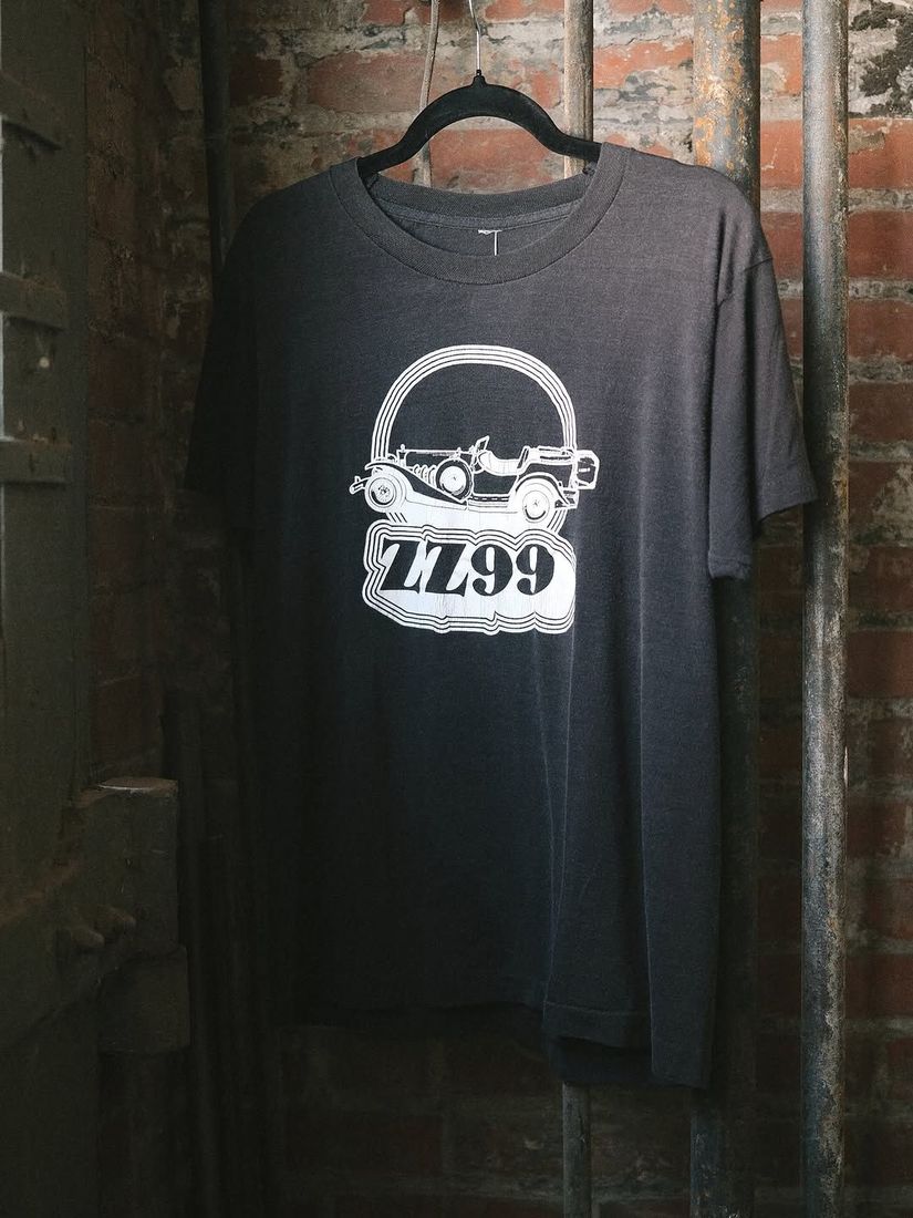 A vintage ZZ99 tee shirt on a hanger against the painted brick wall at 6 Foot Closet